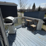 Back deck with BBQ grill and outdoor dining area at Mildred's Lakefront Resort Cottage, Bellmere Winds Golf Resort